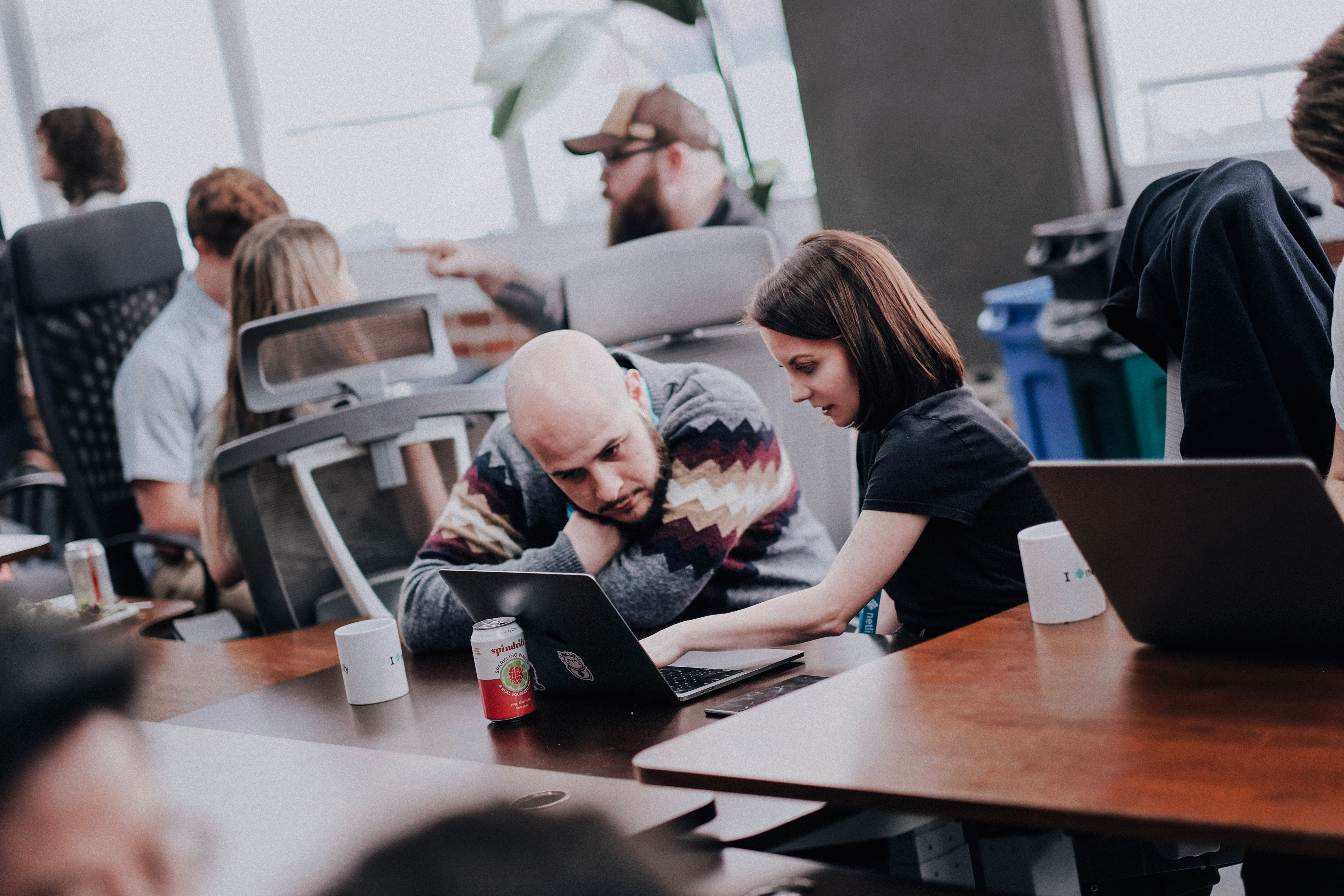 two engineers sitting in front of a laptop and working